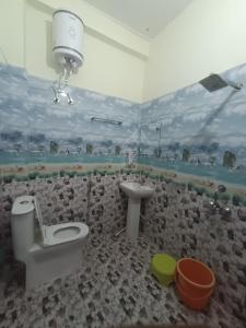 a bathroom with a rock wall with a toilet and a sink at Hotel Swagat Sarovar in Pauri +17 photos