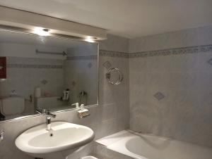 a bathroom with a sink and a mirror and a tub at Maria Apostolou villa in Almiros