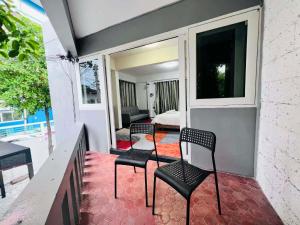 a balcony with two chairs and a room with a bed at Villa Wongamat in North Pattaya