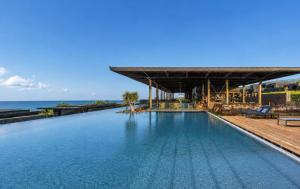 a swimming pool with the ocean in the background at Wood Hôtel & Spa in Saint-Gilles-les-Bains