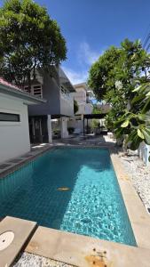 a swimming pool in front of a house at Villa Wongamat in North Pattaya