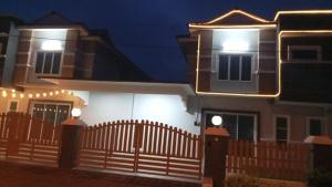 a house with a fence in front of it at night at Pusing Classic Semi D House in Pusing