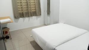 a white room with a bed and a window at Pusing Classic Semi D House in Pusing +4 photos