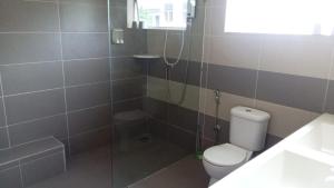 a bathroom with a shower and a toilet and a sink at Pusing Classic Semi D House in Pusing