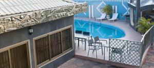 a balcony with a table and chairs next to a pool at Eastgate Hotel in Accra