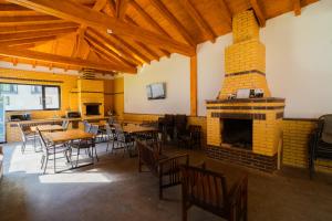 a restaurant with tables and chairs and a fireplace at WhiteBergHaus Colibita in Colibiţa