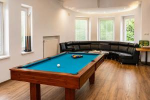 a living room with a pool table and a leather couch at Boutique Hotel at Golf Piestany in Piešťany