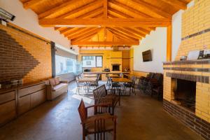 a room with tables and chairs and a fireplace at WhiteBergHaus Colibita in Colibiţa