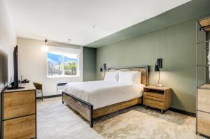 a bedroom with a bed and a window and a television at The Outrider Hotel in Manitou Springs