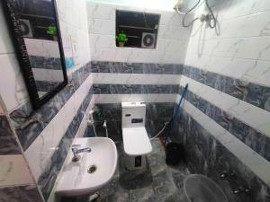 a small bathroom with a toilet and a sink at Deodar Commune in Visakhapatnam