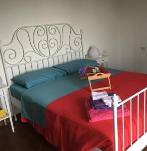 グラヴェドーナにあるCasa Cameliaのベッドルーム1室(赤と青の毛布付きのベッド1台付)