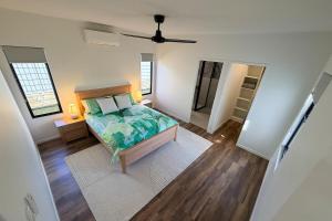 a bedroom with a bed and a ceiling fan at The Village HQ in Yungaburra +9 photos