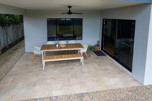 a patio with a table and chairs and a couch at The Village HQ in Yungaburra