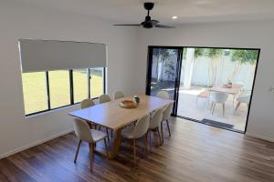 a dining room with a wooden table and chairs at The Village HQ in Yungaburra
