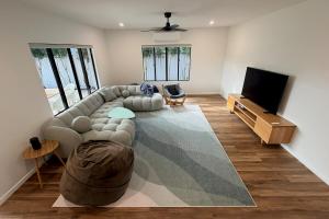 a living room with a couch and a flat screen tv at The Village HQ in Yungaburra