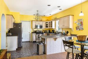 a kitchen with yellow walls and white cabinets at Spacious Seven Peaks Ridge Quiet Side Hot Tub, Pet Friendly, Fire Pit & Deck in Southwest Harbor