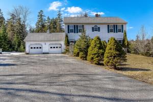 a large white house with two garage doors at Spacious Seven Peaks Ridge Quiet Side Hot Tub, Pet Friendly, Fire Pit & Deck in Southwest Harbor +65 photos