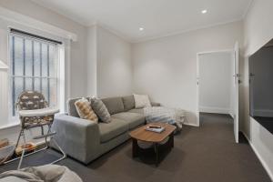 a living room with a couch and a table at Hobart CBD Loft - Walking to CBD in Hobart