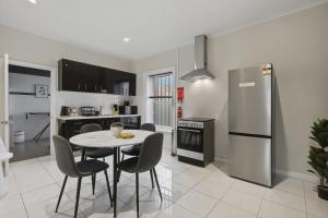 a kitchen with a table and chairs and a refrigerator at Hobart CBD Loft - Walking to CBD in Hobart