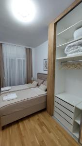 a bedroom with a large bed and a mirror at D&M Lux1 in Podgorica