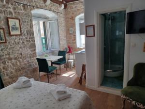 a room with a shower and a table and chairs at Apartments Kaleta in Split +41 photos