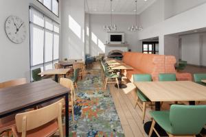 a restaurant with tables and chairs and a clock on the wall at Hampton Inn and Suites Alexandria in Alexandria