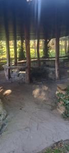 a bench under a roof with the sun shining at Agroturystyka pod Chyrową in Chyrowa