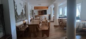 a dining room with a table and chairs and a kitchen at Agroturystyka pod Chyrową in Chyrowa