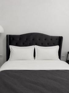 a bed with a black headboard and two white pillows at Sfara Residence Apartament 6 in Baia Mare