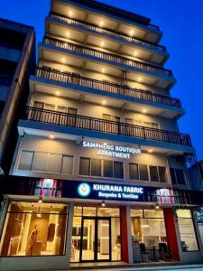 a tall building with a sign in front of it at Sampheng Apartment in Bangkok
