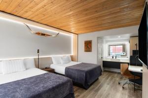 a room with two beds and a desk and a television at The Hotel Pendleton, Trademark Collection by Wyndham in Pendleton