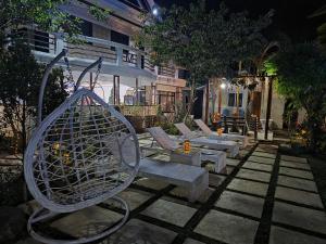 a patio with a bunch of chairs and a fan at Gilkrissa Garden in San Nicolas