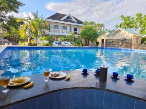 a table with food and drinks next to a swimming pool at Gilkrissa Garden in San Nicolas