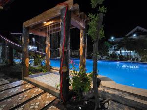 a wooden gate in front of a swimming pool at night at Gilkrissa Garden in San Nicolas