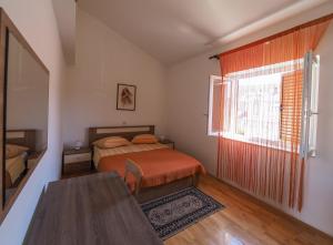 a bedroom with a bed and a window and a table at Apartman Seven Waves in Punat