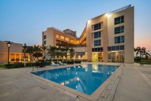 a building with a swimming pool in front of a building at Ramada by Wyndham Bodh Gaya Mahabodhi in Bodh Gaya