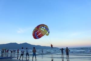 un grupo de personas en la playa volando una cometa en Misa Hotel Da Nang, en Da Nang
