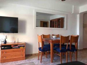 a dining room with a table and chairs and a television at Mediterranean Apartment with WIFI in Canet de Berenguer
