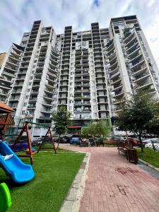 a large apartment building with a playground in front of it at Central Cozy 2-Bedroom in Tbilisi City