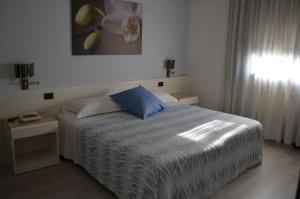 ein Schlafzimmer mit einem Bett mit einem blauen Kissen in der Unterkunft Hotel Giovanni in Padua