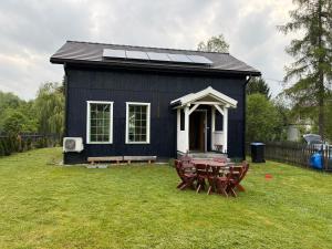 a small black house with a picnic table and a picnic table sidx sidx at Dom Galicja in Radziechowy