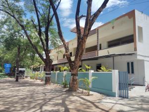 a building with trees in front of it at AYYAN RESIDENCY in Alāndurai