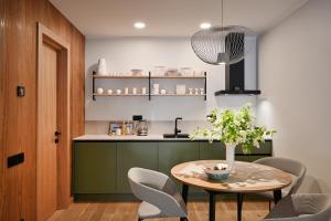 a kitchen with a table and chairs and a kitchen with a counter at Albatross Home in Ķesterciems