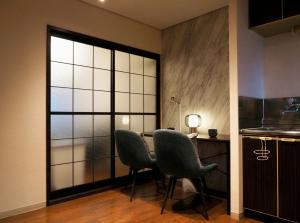 a room with two chairs and a table and a window at #52 Towny Yanagihara in Numazu