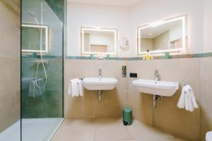 a bathroom with two sinks and a shower at Hotel Ritter Badenweiler in Badenweiler