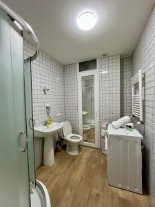 a bathroom with a toilet and a sink and a shower at Central Cozy 2-Bedroom in Tbilisi City