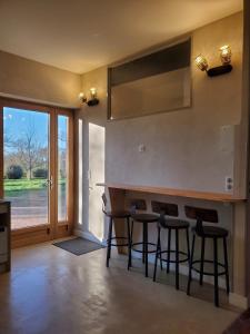 a kitchen with a bar with stools and a window at Logement authentique et facile d'accès in Sermoise