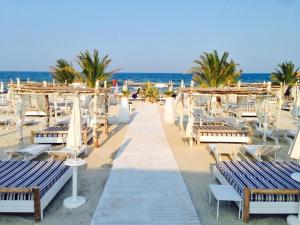 a beach with chairs and umbrellas and the ocean at Desilva Residences - Loft Club in Mamaia