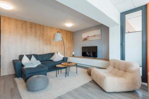 a living room with a couch and a chair and a tv at Deich 71 in Borkum