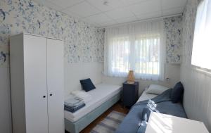 a small room with a bed and a couch at LelleBlue Vendégház in Balatonlelle
